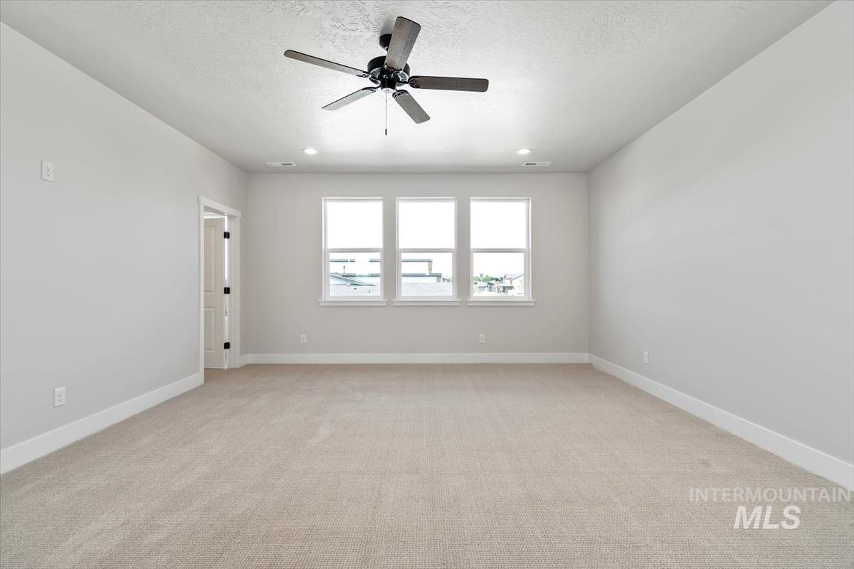 2830 West Jutland Street Meridian, ID 83642 - Photo 22 of 40 Empty room with light carpet, ceiling fan, a textured ceiling, and recessed lighting