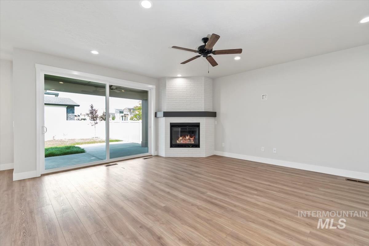 2830 West Jutland Street Meridian, ID 83642 - Photo 6 of 40 Unfurnished living room with ceiling fan, light wood finished floors, a fireplace, and recessed lighting
