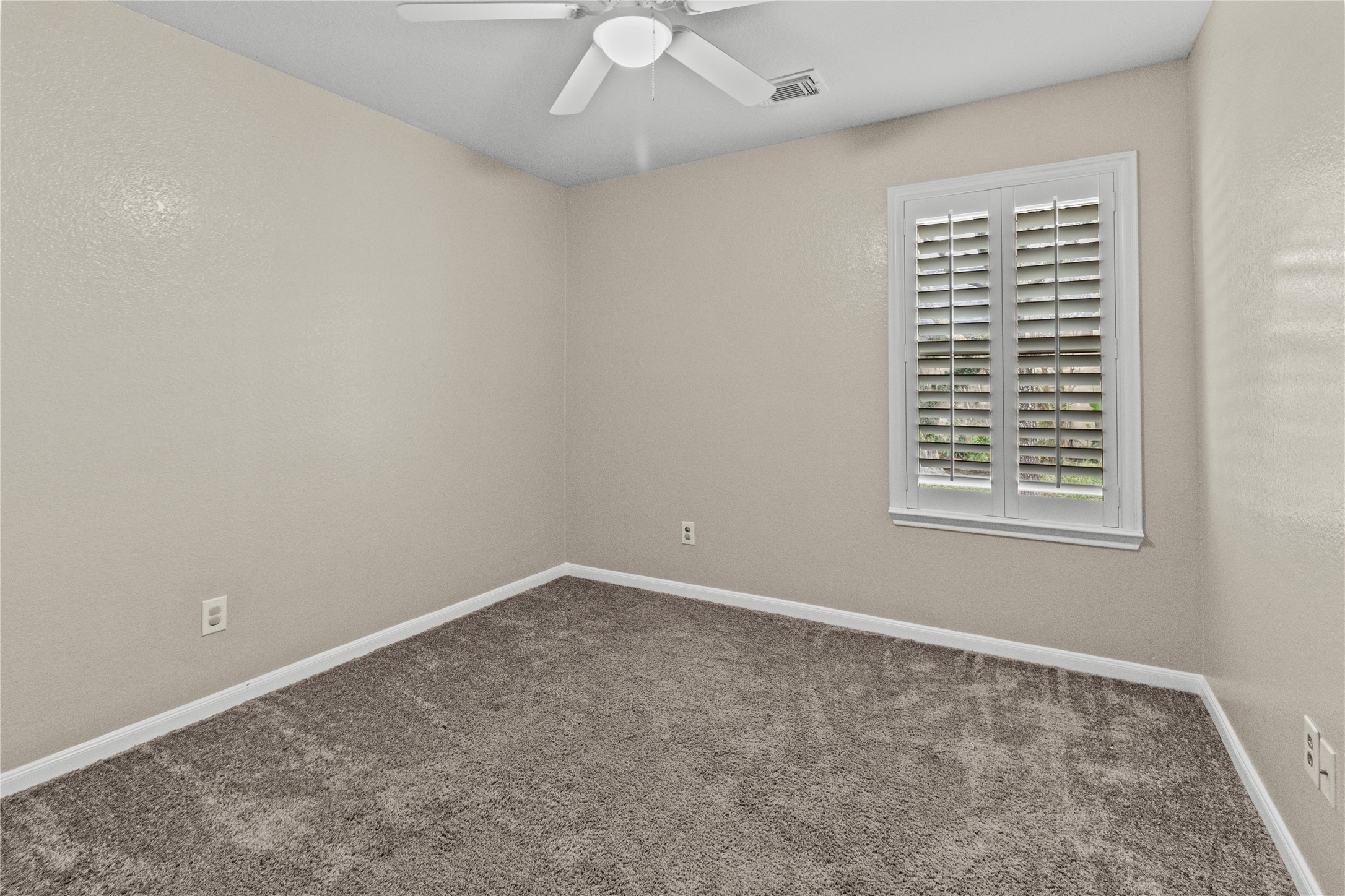 7922 Owl Lane Baytown, TX 77523 - Photo 12 of 25 an empty room with a window and a fan