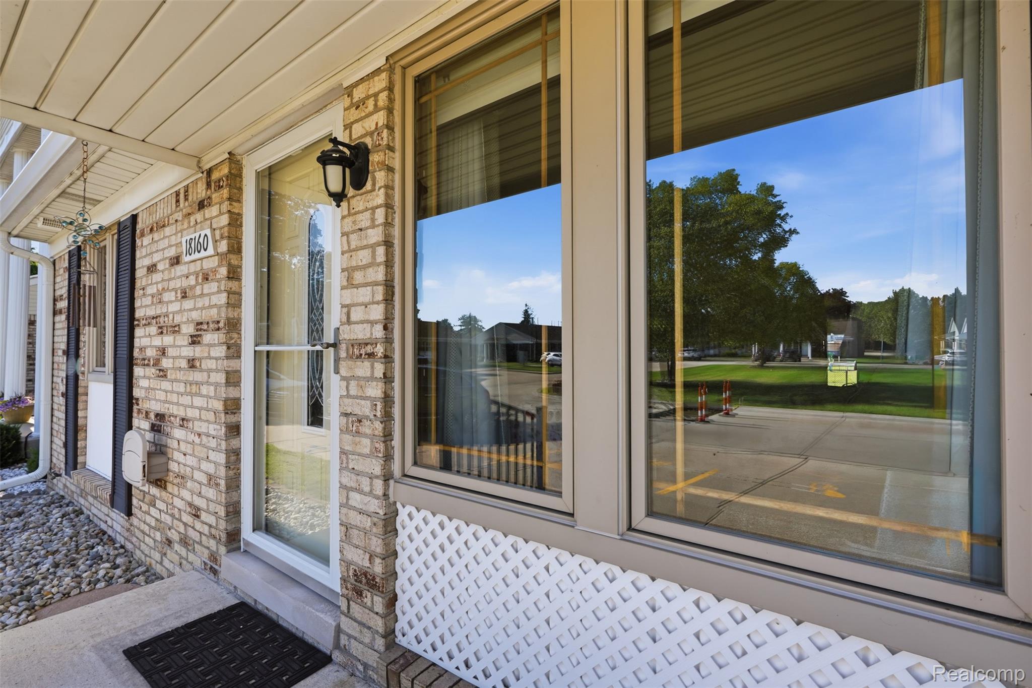 18160 Raleigh Square Drive Southgate, MI 48195 - Photo 5 of 31 Brick exterior featuring a covered entry, decorative storm door, and an exterior wall lantern
