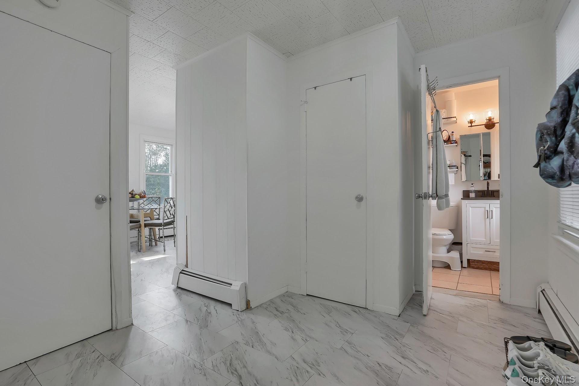 71 Greycourt Road Chester, NY 10918 - Photo 10 of 38 Corridor featuring light marble finish flooring and a baseboard heating unit