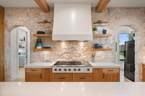a kitchen with stainless steel appliances granite countertop a sink stove and cabinets