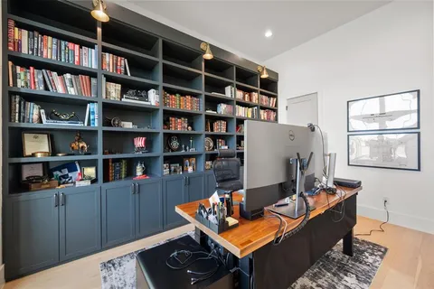 a living room with couches and kitchen view with wooden floor