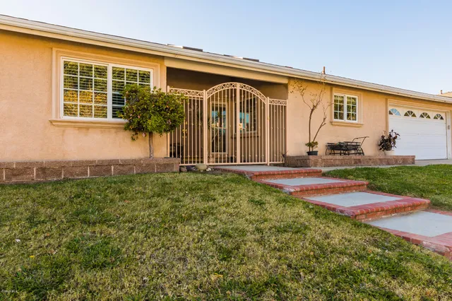 a backyard of a house with table and chairs