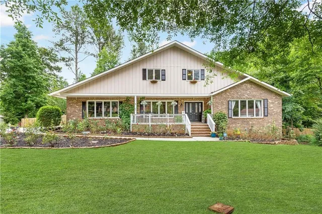 a view of a house with a yard and a porch