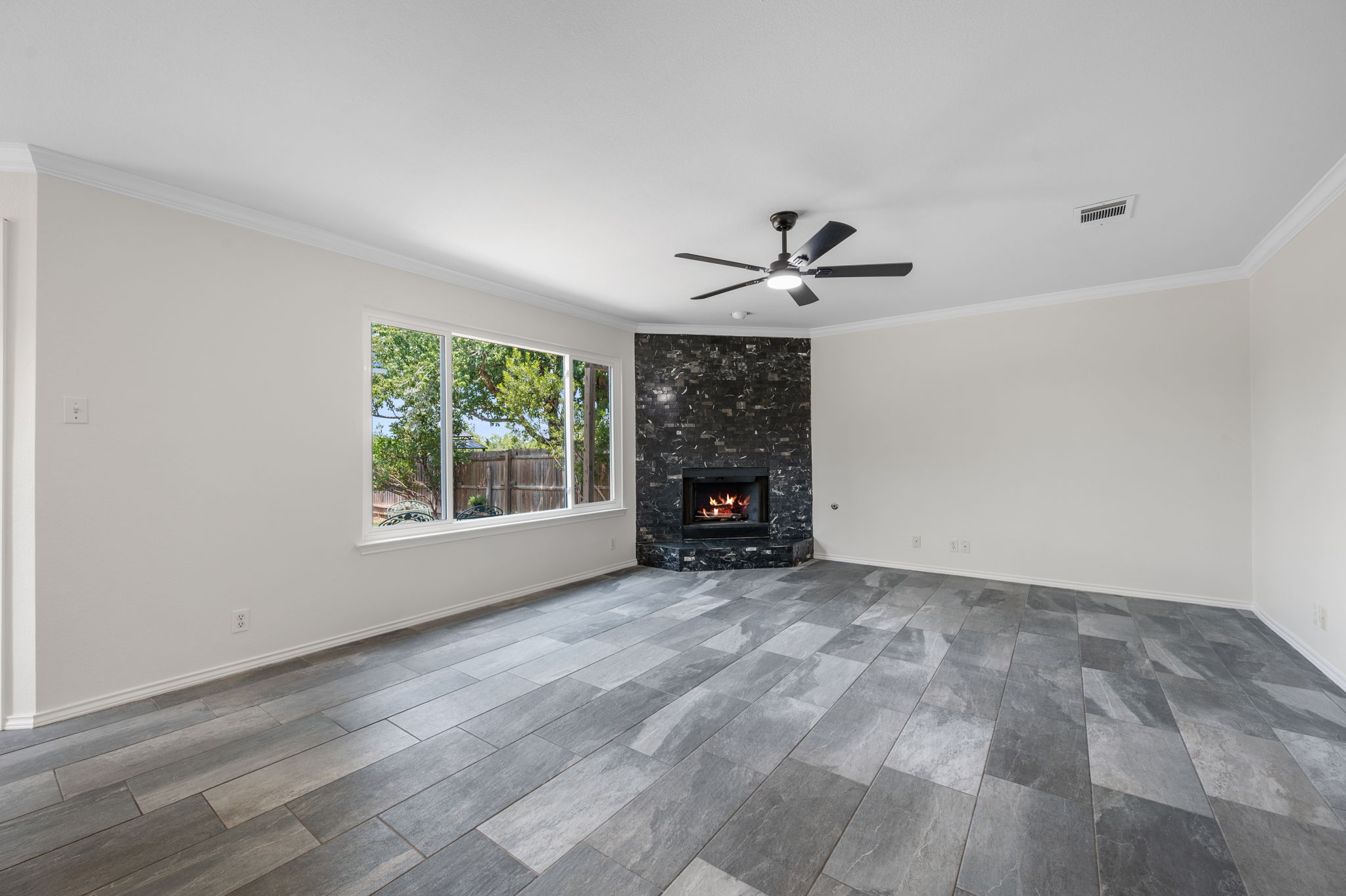 2440 Madeline Loop Cedar Park, TX 78613 - Photo 15 of 33 Unfurnished living room with ornamental molding, a ceiling fan, wood tiled floors, and a fireplace