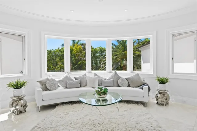 a bedroom with a bed a flat screen tv and a large window