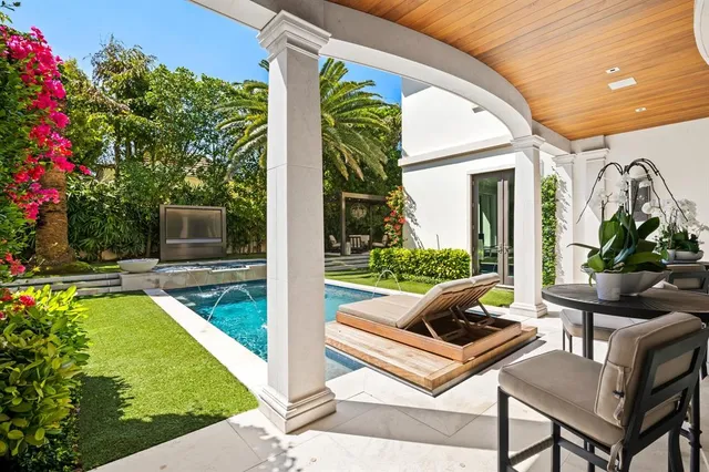 a view of a patio with table and chairs potted plants and palm trees