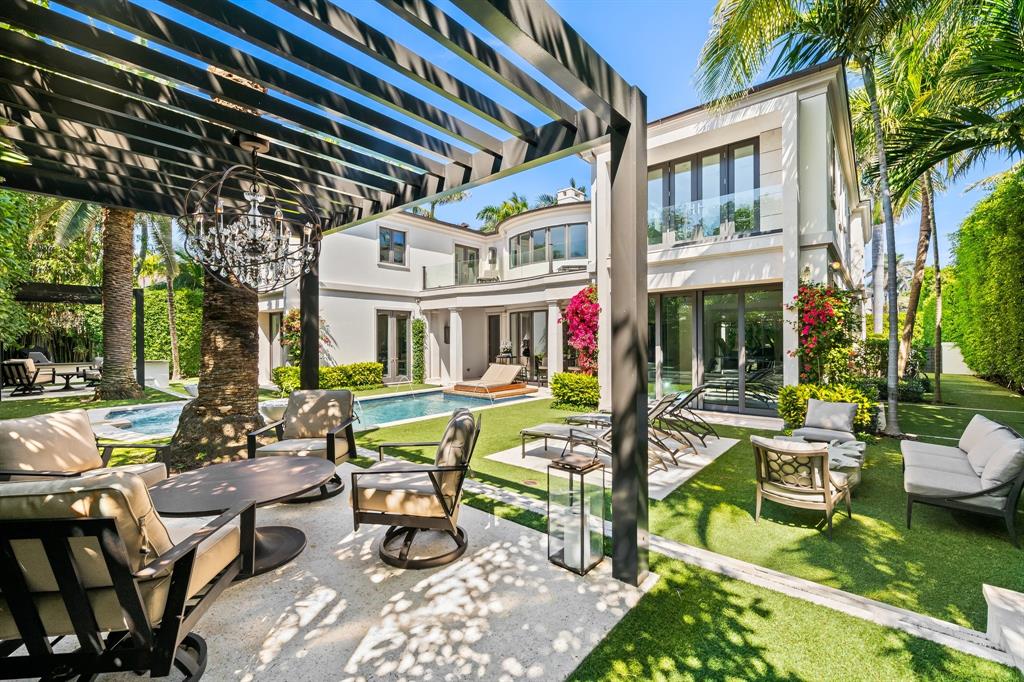 150 Kings Road Palm Beach, FL 33480 - Photo 40 of 45 a view of a patio with table and chairs potted plants and palm trees
