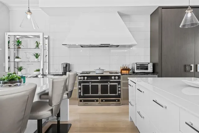 a large white kitchen with lots of counter space and refrigerator