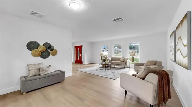 a kitchen with stainless steel appliances kitchen island granite countertop a sink a stove a refrigerator and island with wooden floor