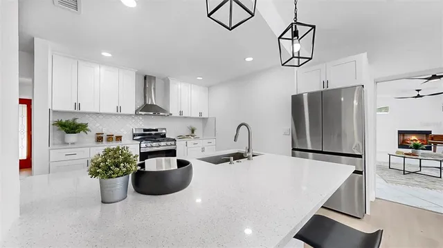 a kitchen with stainless steel appliances granite countertop a refrigerator a sink and a stove