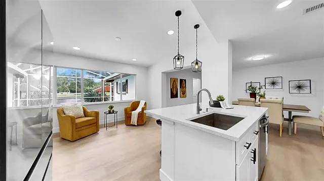 a living room with furniture a flat screen tv and a floor to ceiling window