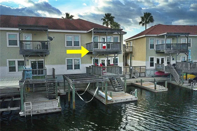 a view of a patio with couches table and chairs under an umbrella