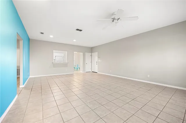 an empty room with windows and fan