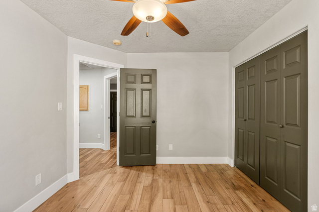 55 Spring Drive Toquerville, UT 84774 - Photo 22 of 36 Unfurnished bedroom featuring light wood finished floors, a closet, ceiling fan, and a textured ceiling