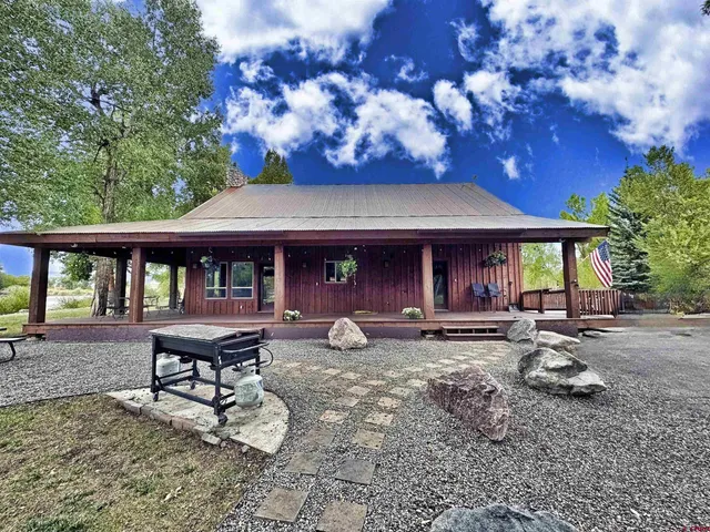 a view of a wooden deck and a yard with the trees