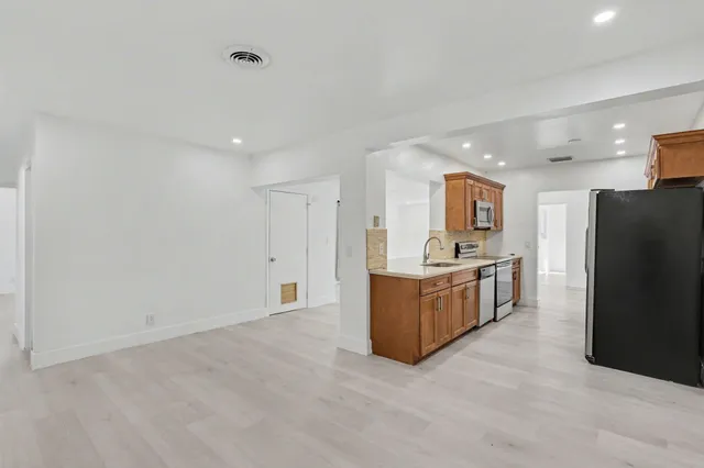 a large white kitchen with cabinets and stainless steel appliances