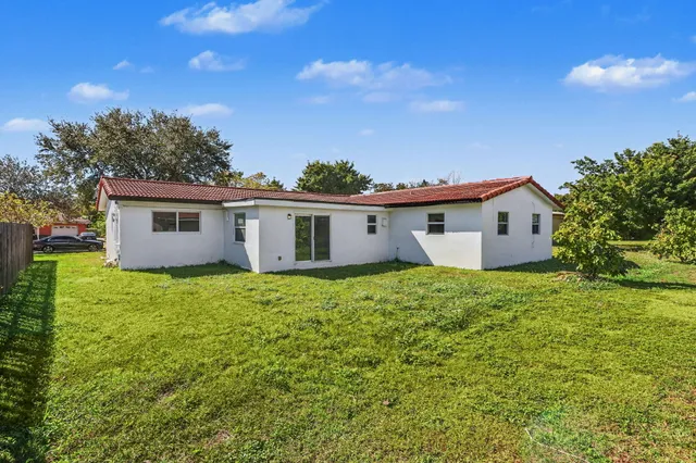 a view of a house with backyard and garden