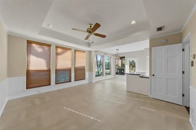 a view of an empty room with window and chandelier