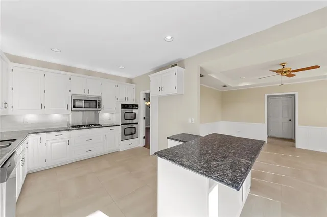 a kitchen with granite countertop a sink stove and refrigerator