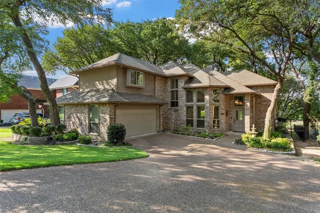 a view of a house with a yard and large trees