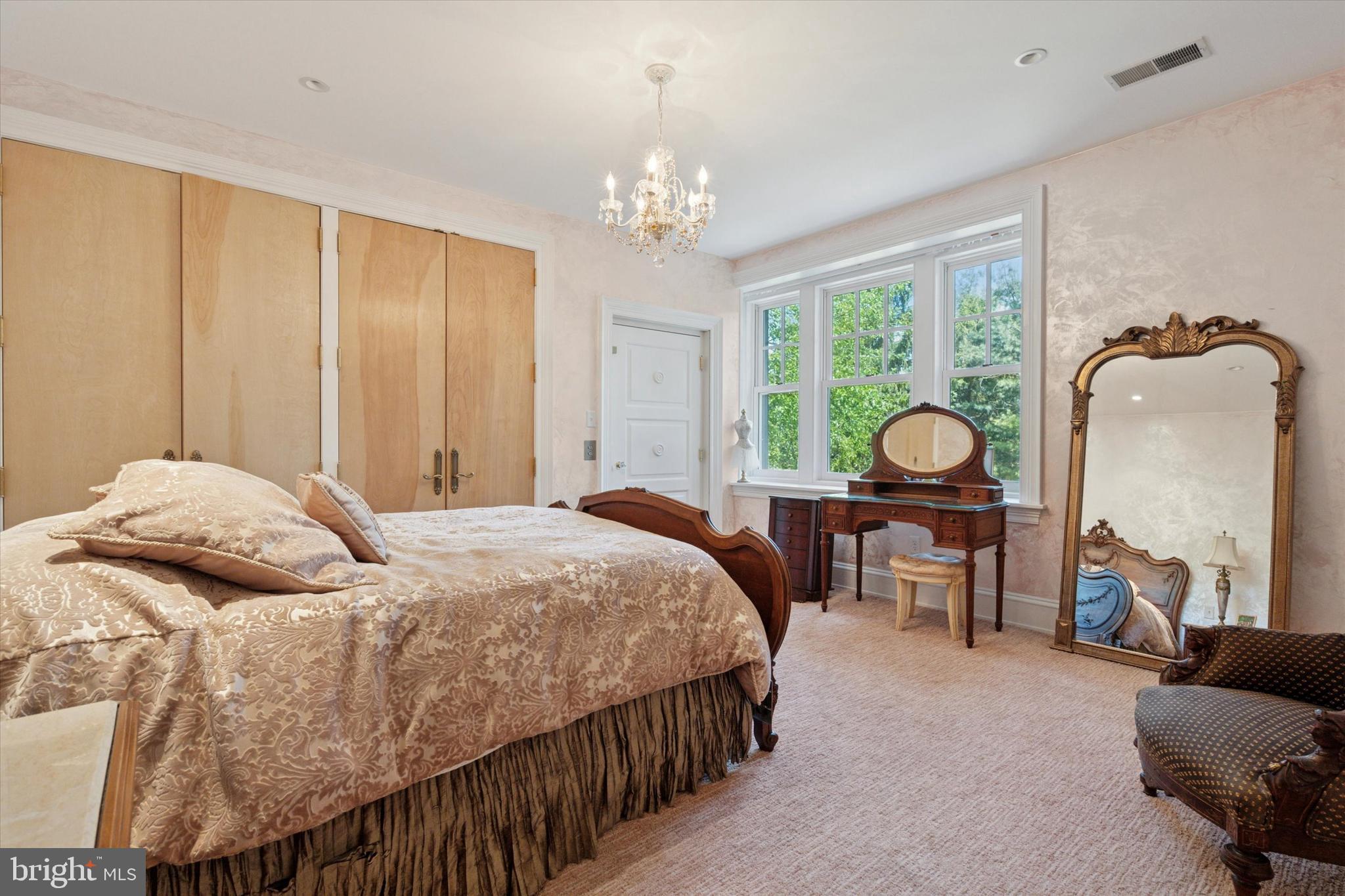 281 Winding Way Merion Station, PA 19066 - Photo 28 of 52 a bedroom with a bed a chandelier and dresser