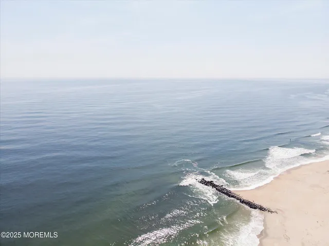 a kitchen with a sink wooden floor and stainless steel appliances