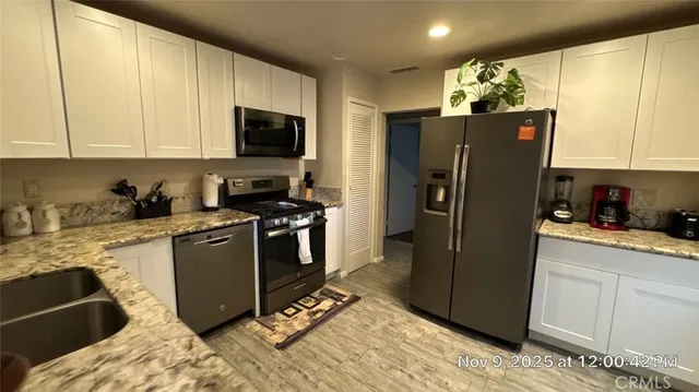 a kitchen with stainless steel appliances granite countertop a refrigerator stove and microwave