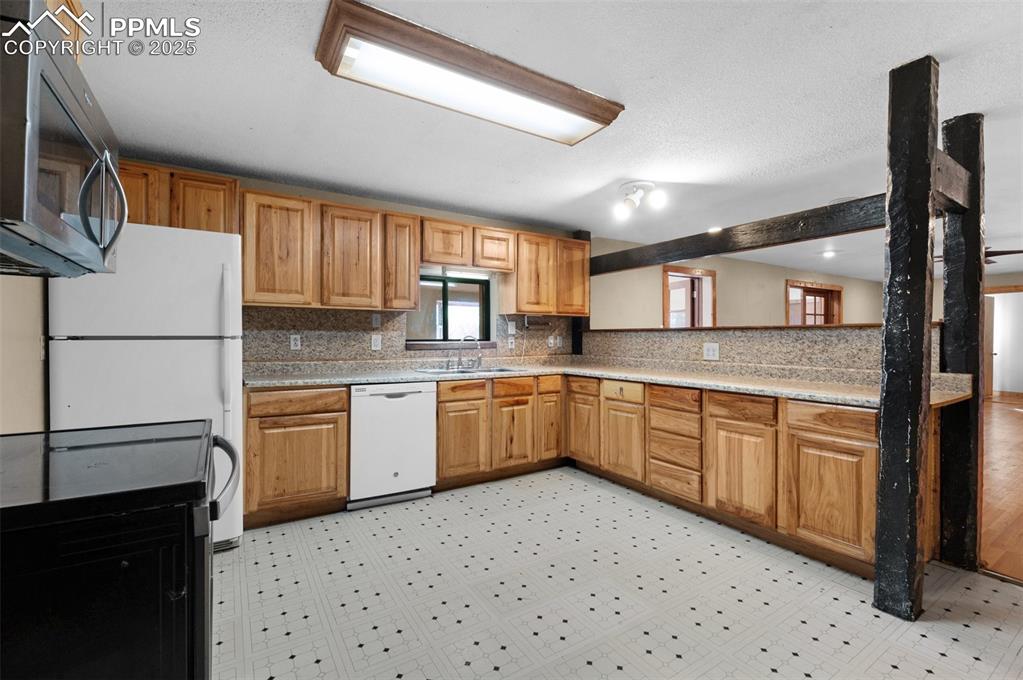 27720 Mid Jones Road Calhan, CO 80808 - Photo 12 of 43 a kitchen with granite countertop a sink appliances cabinets and furniture