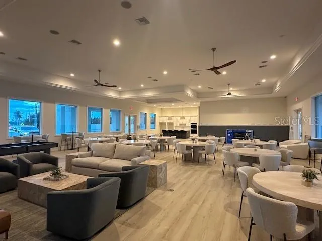 a living room with furniture kitchen area and a wooden floor