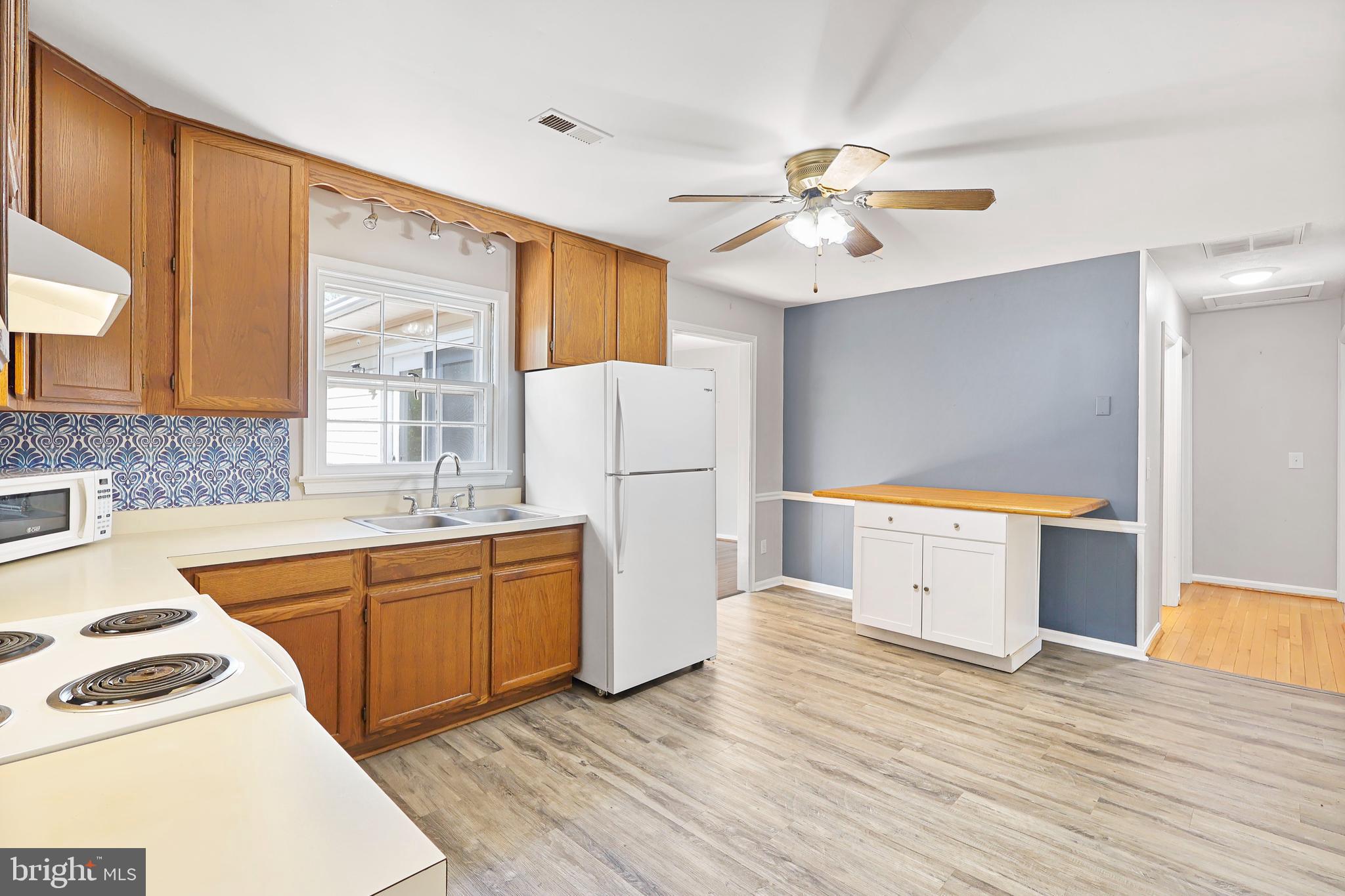 15366 Black Hill Road Rixeyville, VA 22737 - Photo 15 of 35 a kitchen with a refrigerator a stove top oven a sink and dishwasher with wooden floor