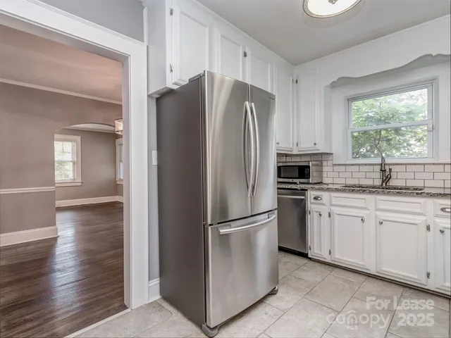a kitchen with granite countertop stainless steel appliances a refrigerator sink and cabinets