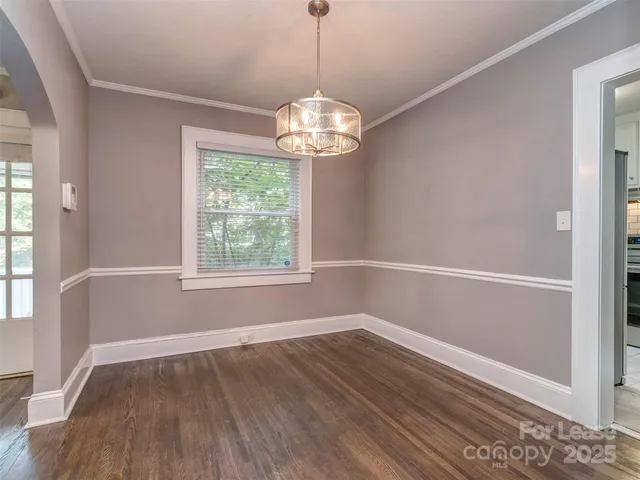 a view of a room with wooden floor chandelier and window