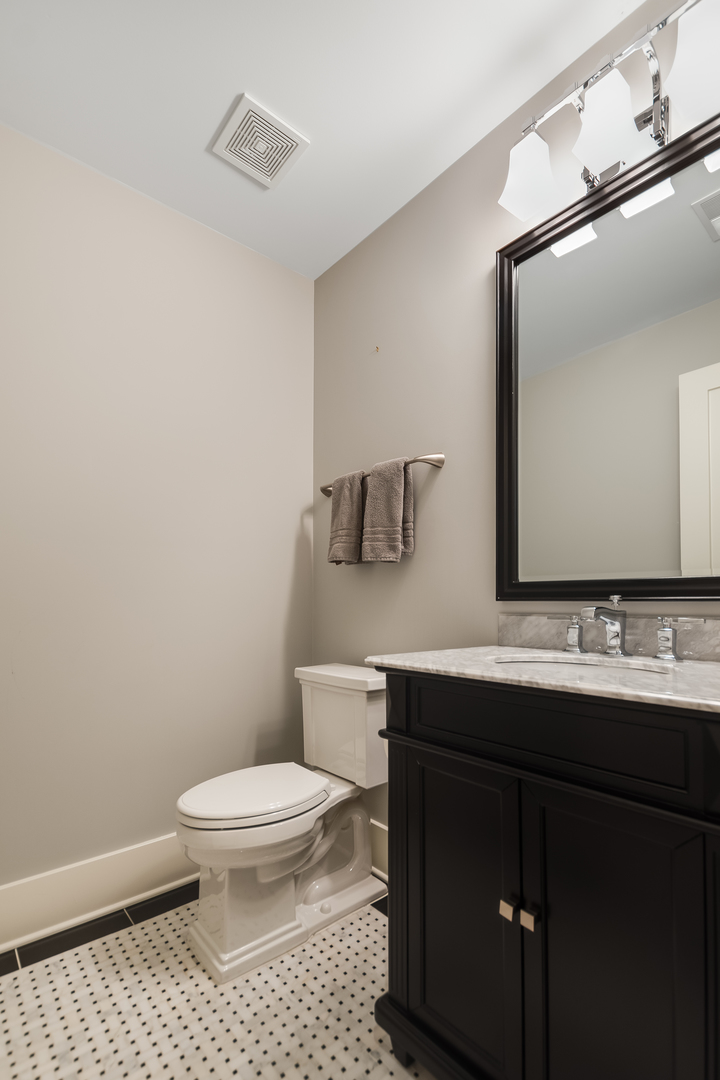 1480 West Grace Street Chicago, IL 60613 - Photo 35 of 41 a bathroom with a sink a toilet a mirror and vanity
