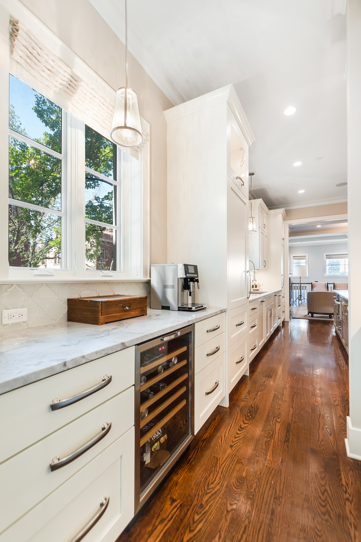 1480 West Grace Street Chicago, IL 60613 - Photo 7 of 41 a large kitchen with granite countertop a large window and white cabinets