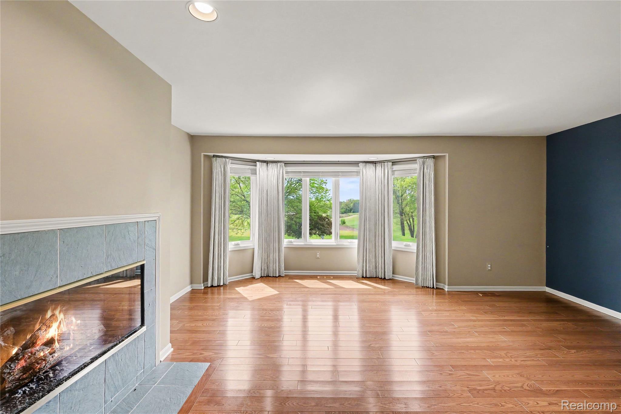 4179 St Andrews Street Howell, MI 48843 - Photo 27 of 75 Primary bedroom features tons of natural light and gas fireplace.