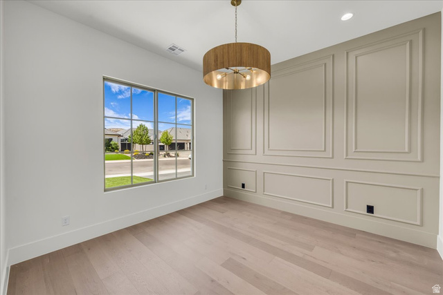 1620 Belayer Drive St. George, UT 84770 - Photo 18 of 51 Room featuring light wood-finish flooring, a large multi-pane window, and a decorative accent wall with panel molding