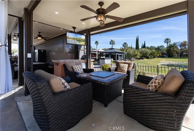 a living room with furniture a flat screen tv and a floor to ceiling window