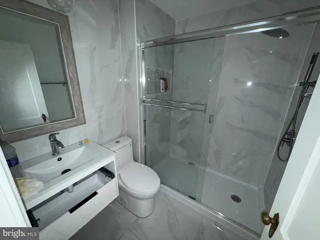 a bathroom with a sink and mirror with toilet