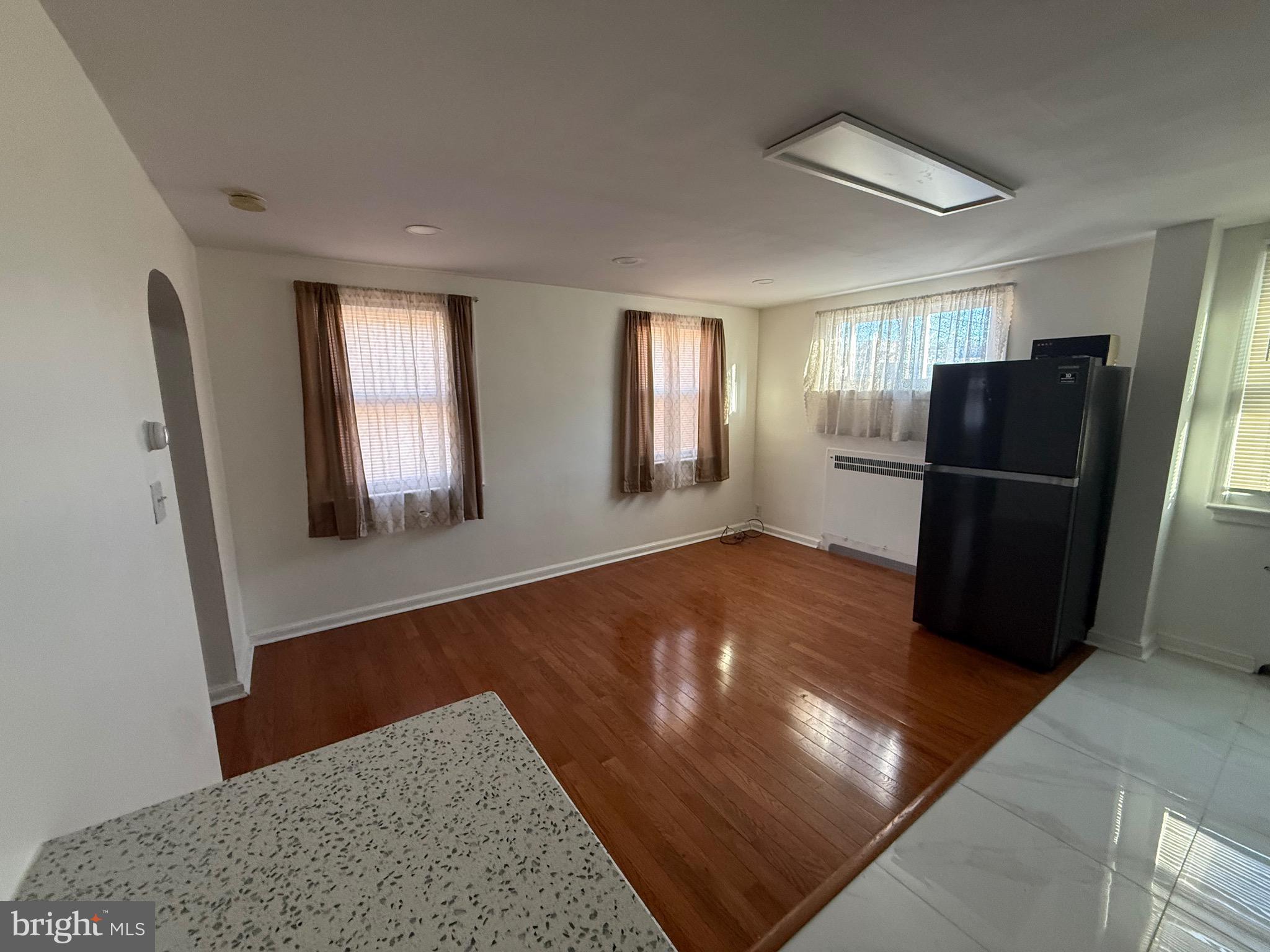 363 Sherbrook Boulevard Upper Darby, PA 19082 - Photo 3 of 12 a view of a livingroom with wooden floor and a kitchen