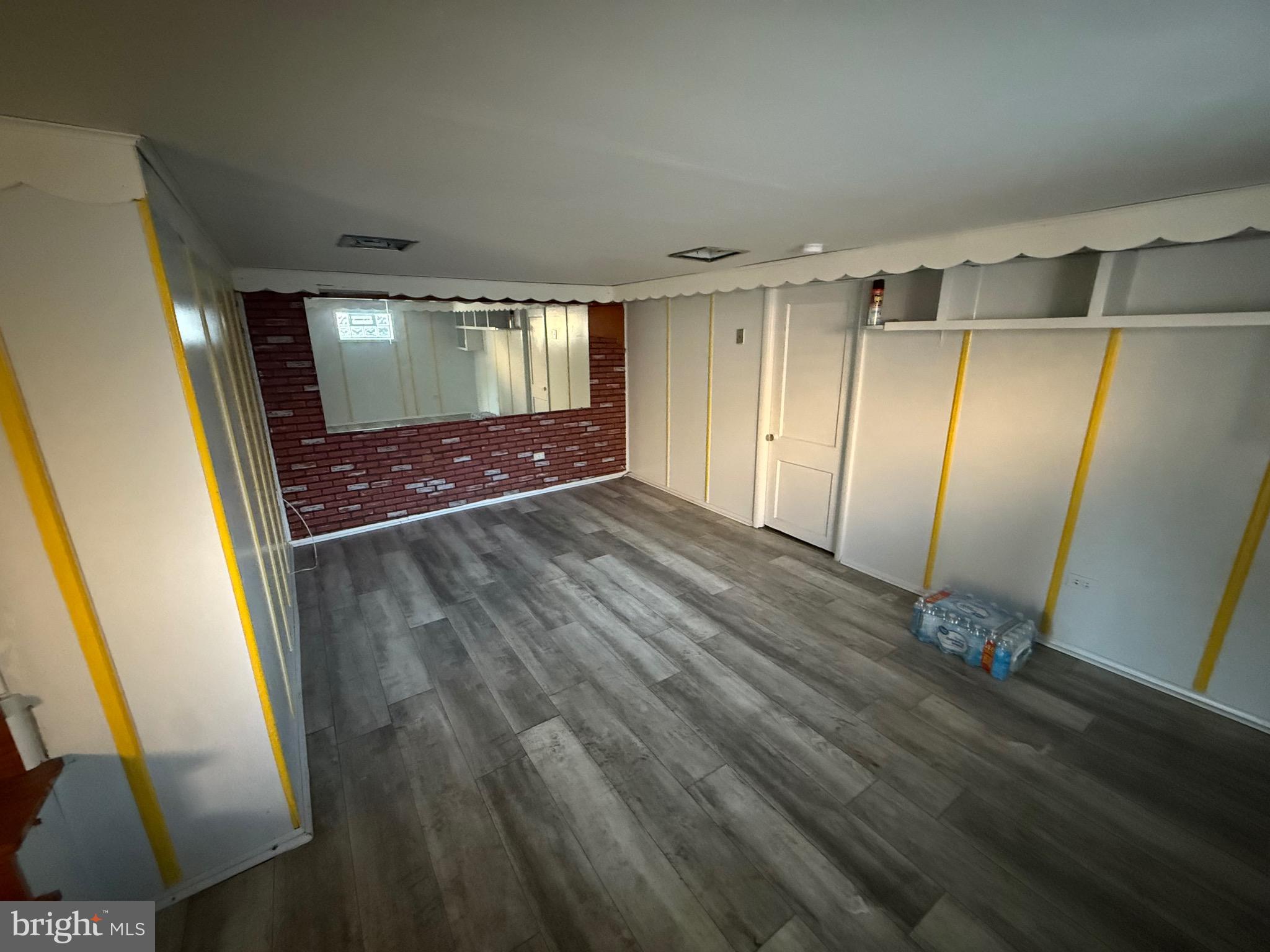 363 Sherbrook Boulevard Upper Darby, PA 19082 - Photo 5 of 12 an empty room with wooden floor and mirror