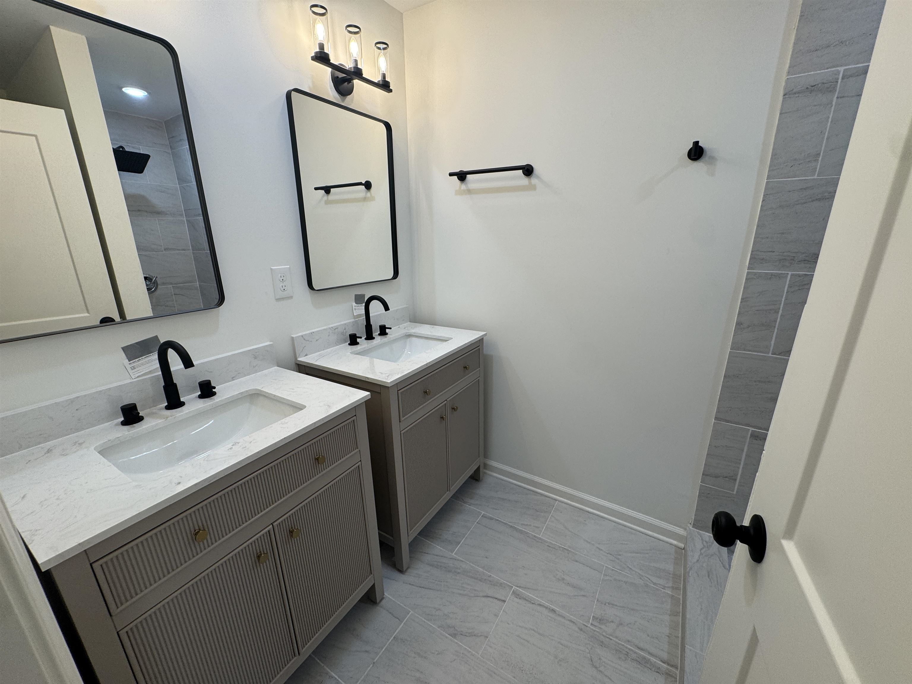 33 North Merton Street Memphis, TN 38112 - Photo 12 of 14 Full bathroom featuring two vanities, light marble finish flooring, and tiled shower