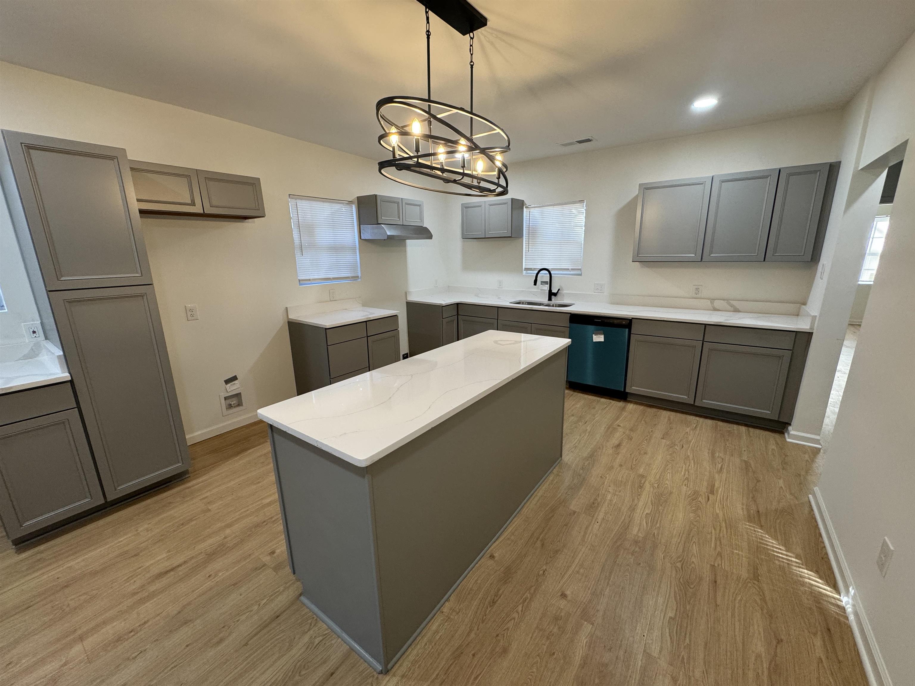 33 North Merton Street Memphis, TN 38112 - Photo 3 of 14 Kitchen featuring gray cabinets, light wood finished floors, dishwasher, suspended lighting, and a center island