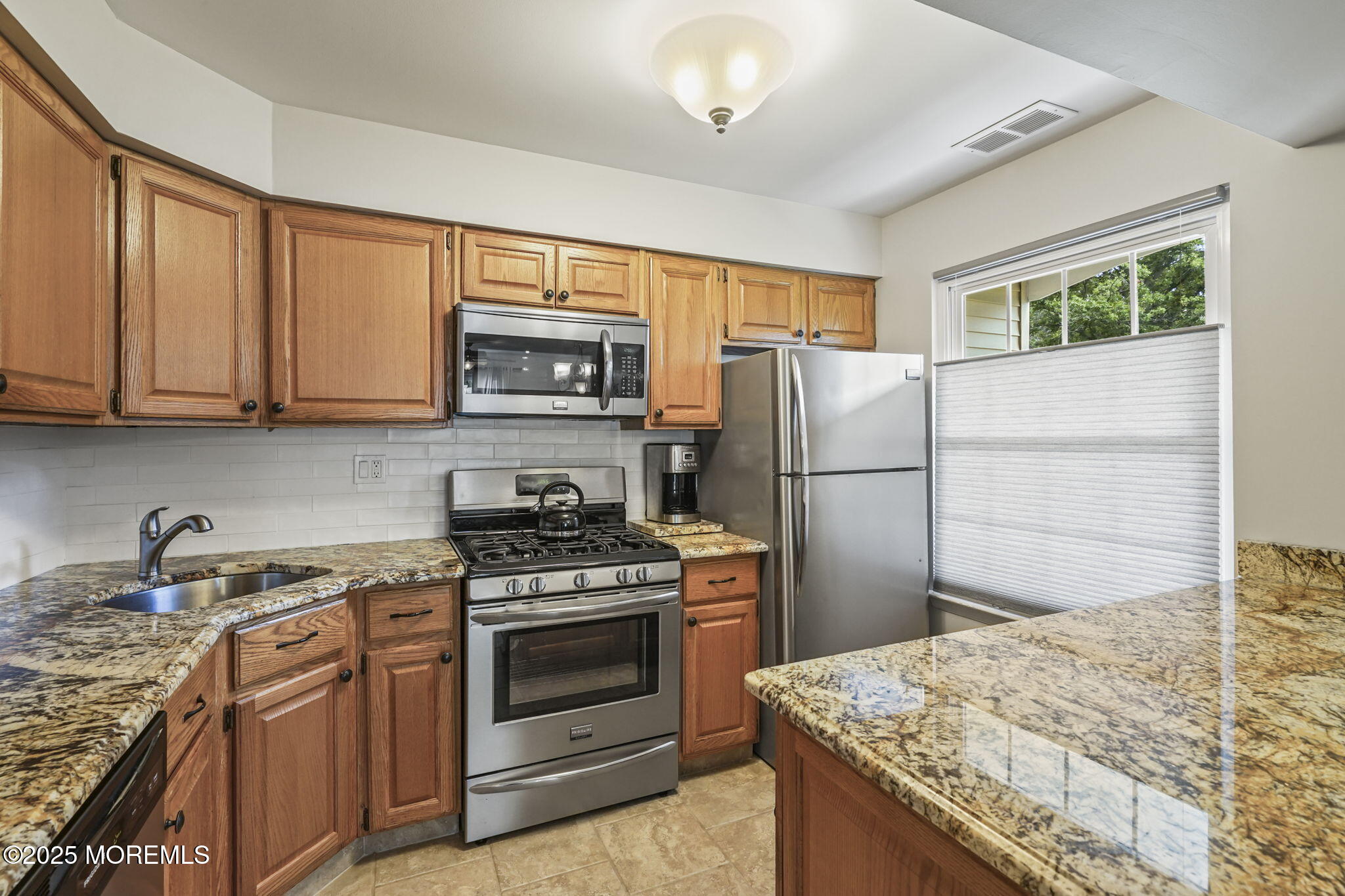 126 Wyckoff Mills Road, Unit 84 Hightstown, NJ 08520 - Photo 4 of 16 a kitchen with stainless steel appliances granite countertop a refrigerator stove and sink