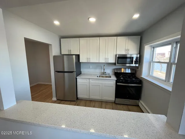 a kitchen with a refrigerator a stove top oven a sink and dishwasher
