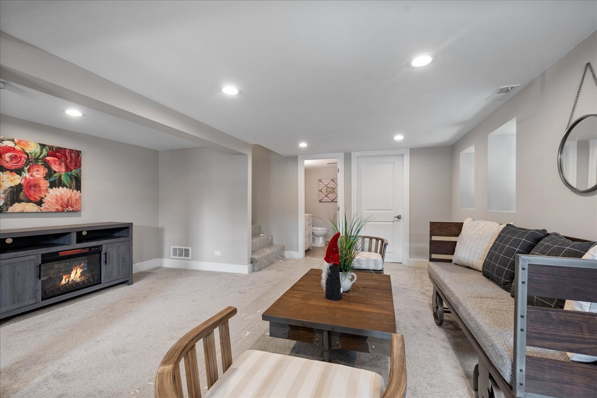 4855 West School Street Chicago, IL 60641 - Photo 23 of 29 a living room with furniture and a flat screen tv