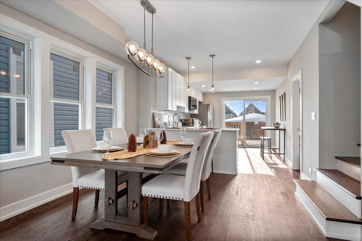 4855 West School Street Chicago, IL 60641 - Photo 7 of 29 a dining room with stainless steel appliances kitchen island granite countertop a table chairs and a refrigerator