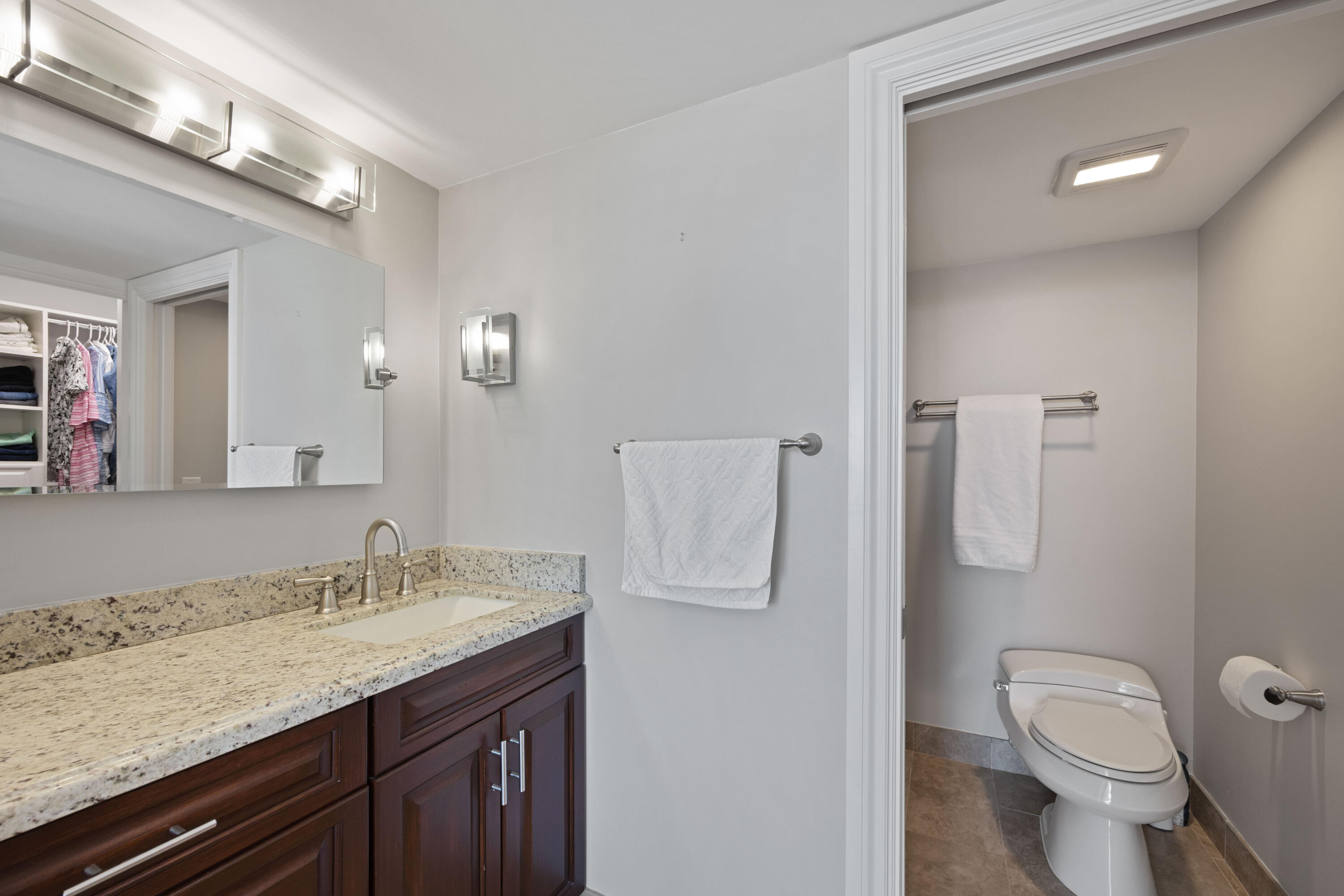 2401 Marina Isle Way, Unit 503 Jupiter, FL 33477 - Photo 18 of 30 a bathroom with a granite countertop sink toilet and shower