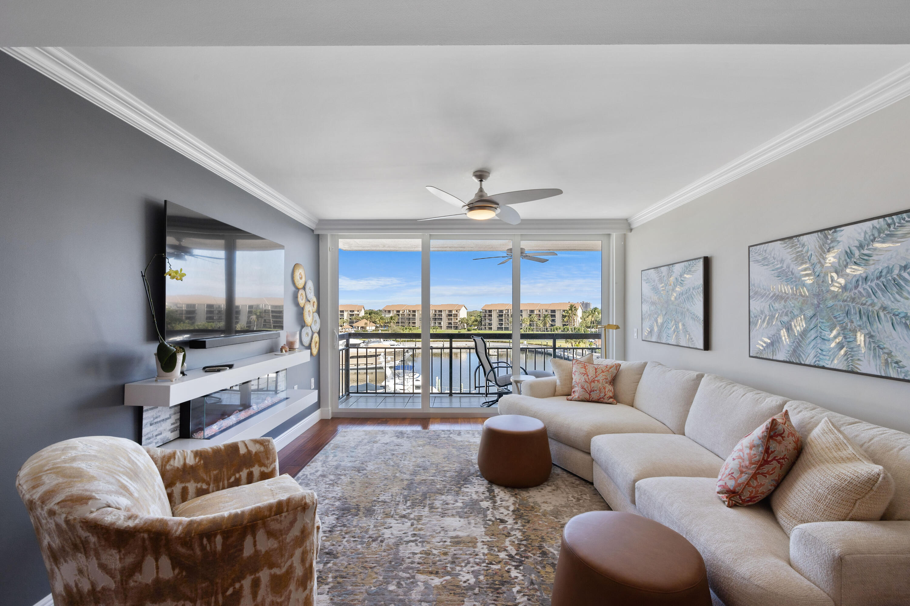 2401 Marina Isle Way, Unit 503 Jupiter, FL 33477 - Photo 8 of 30 a living room with furniture a ceiling fan and a flat screen tv